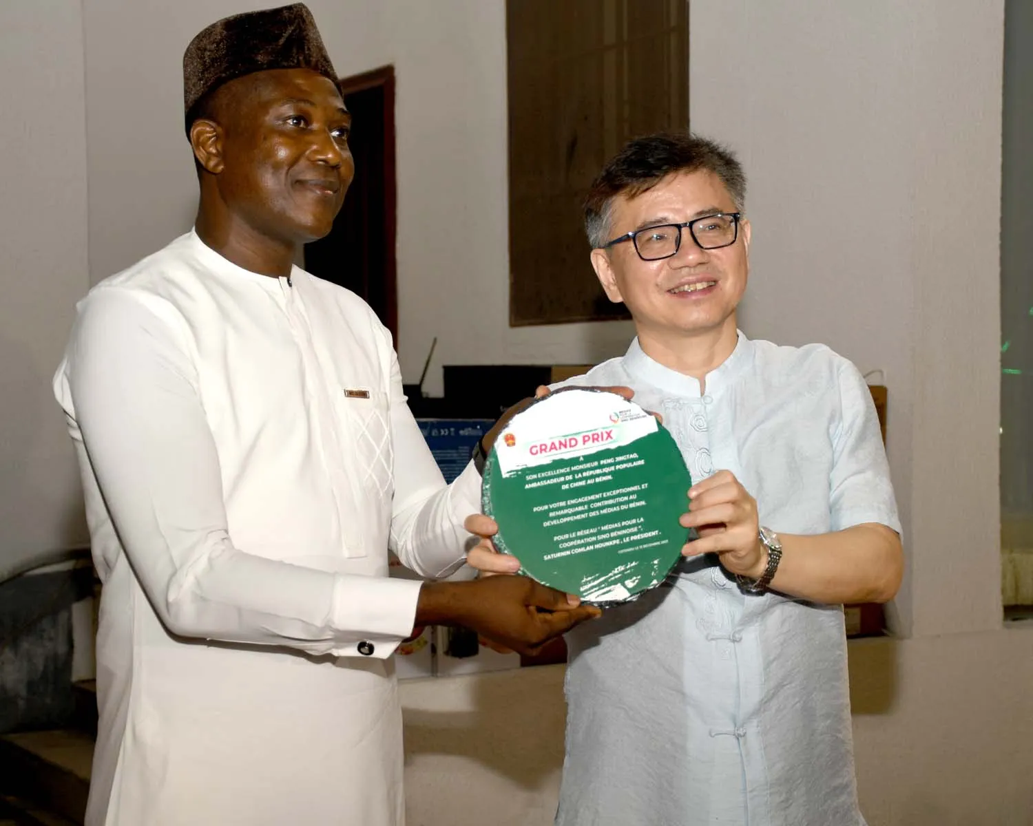 Peng Jingtao recevant sa distinction des mains du représen- tant du Réseau médias pour la coopération sino-béninoise
