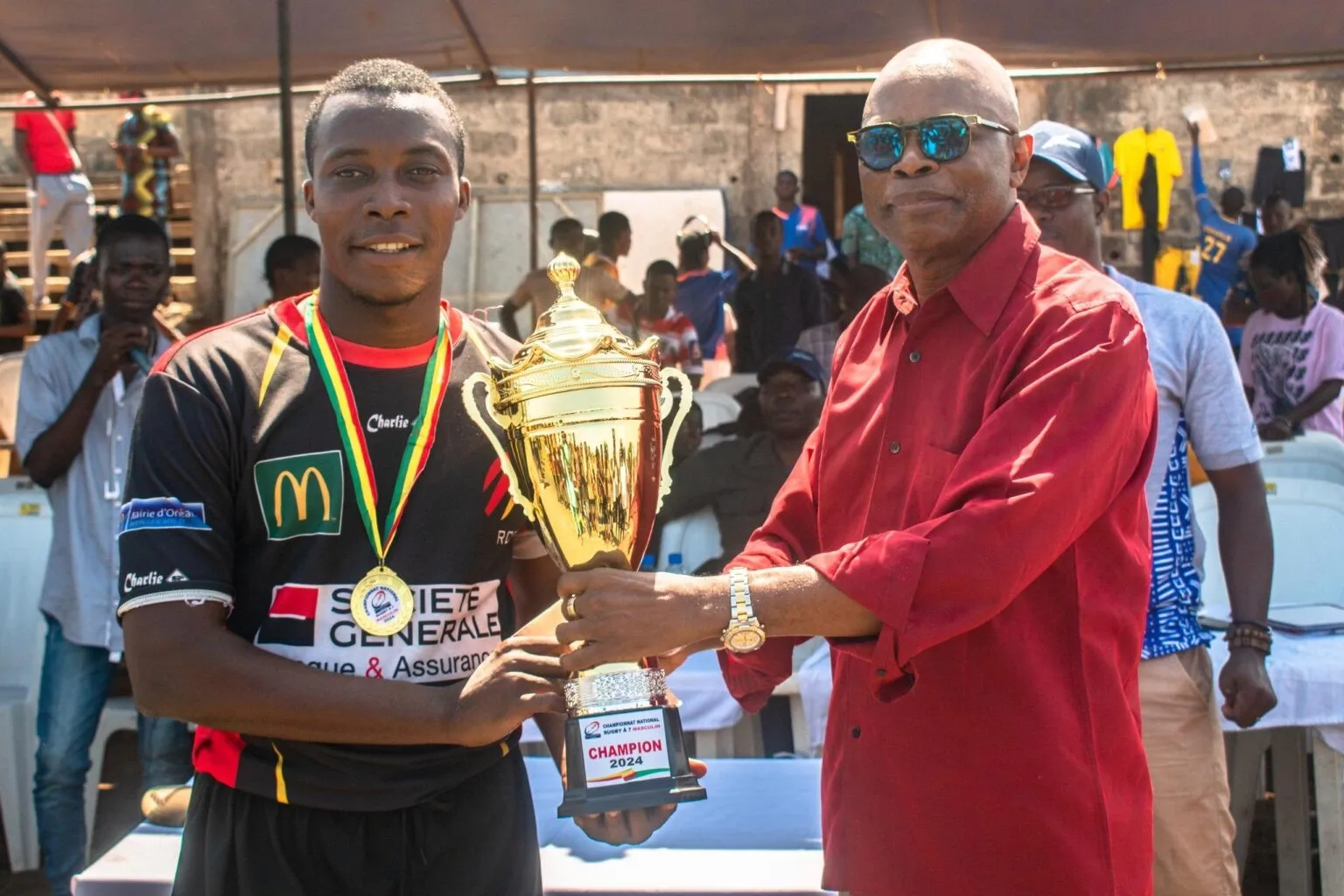 Le président Dahito remettant le trophée  au capitaine des Dauphins