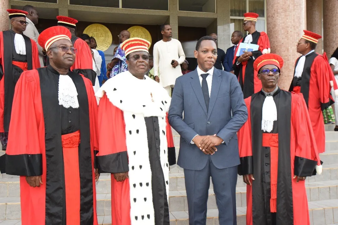 Le nouveau procureur général (à gauche) et le nouveau greffier en chef près la Cour suprême encadrant le président de la Cour suprême et le ministre en charge de la Justice (en costume)