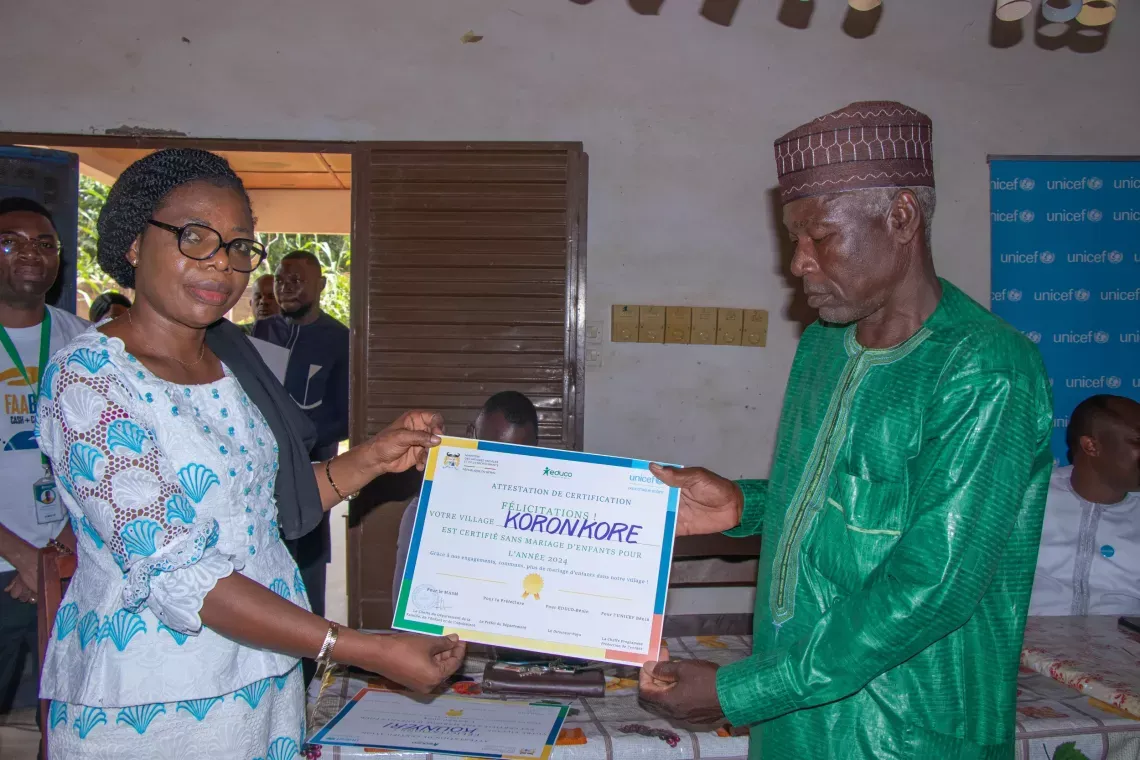 Brigitte Ouin-Ouro, cheffe du département de la famille, de  l’enfant et de l’adolescent fière de remettre le certificat au représentant du village Koronkoré