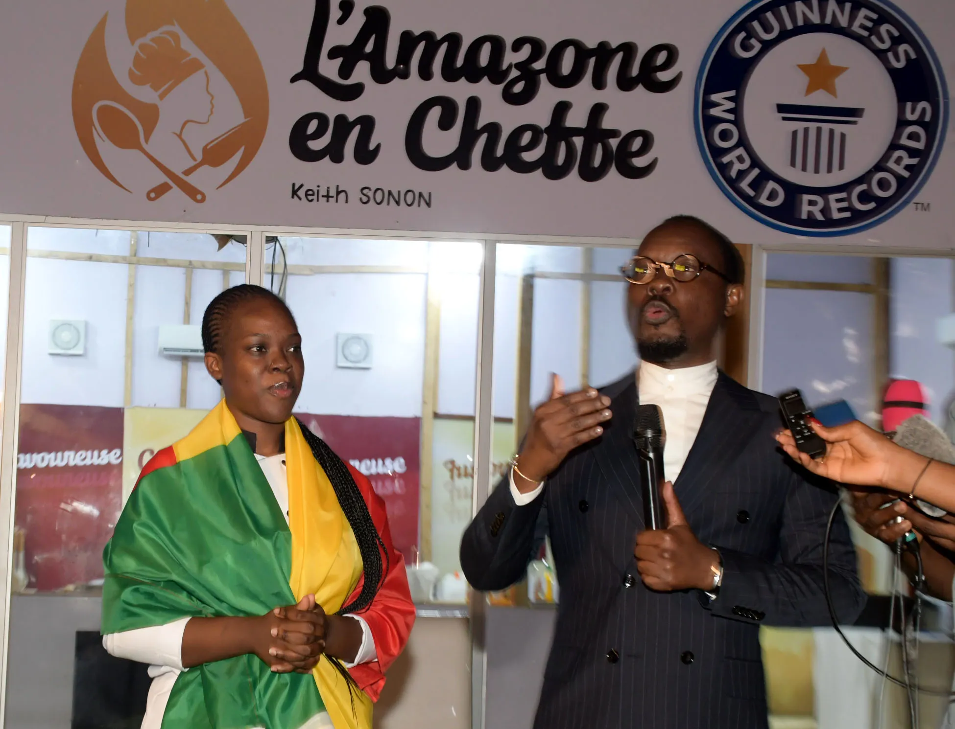Le ministre des Pme Modeste Kérékou, (au micro)  encourageant Keith Sonon dans son marathon culinaire, déterminée à inscrire le nom du Bénin dans le livre des records mondiaux