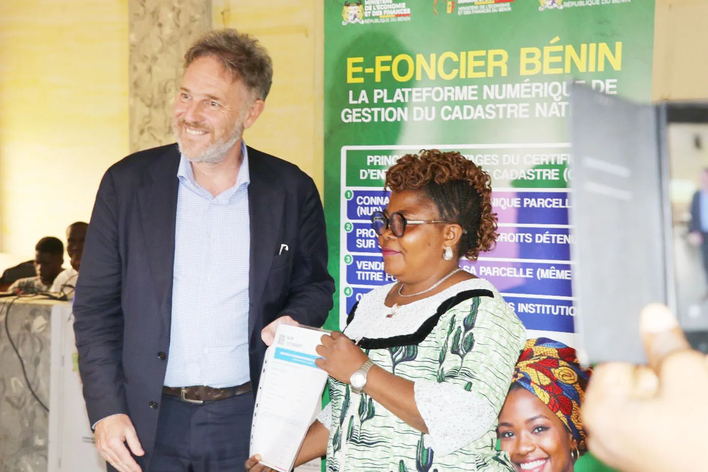 L’ambassadeur du Royaume des Pays-Bas procédant à la remise d’un certificat  d’enregistrement au cadastre à une bénéficiaire